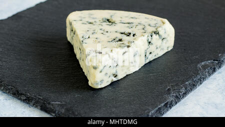 Blue Stilton cheese moule près du coin jusqu'au plateau de fromage en ardoise noire avec selective focus Banque D'Images