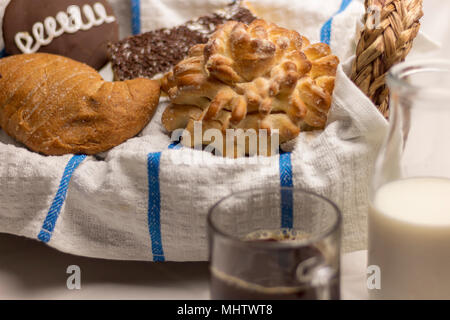 assortiment de pains pour un café du matin fraîchement préparé et du lait sur un linge de table blanc et un panier de fouette. gâteries sucrées pleines d'énergie Banque D'Images