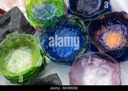 Plaques de verre décoratif ou plats de bleu, vert, rose en piles de couleur sur une table Banque D'Images