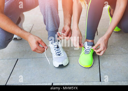 La femme et l'homme le laçage des chaussures de course avant l'entraînement. Close up. Concept de remise en forme et d'un style de vie sain Banque D'Images