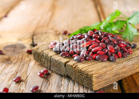 Haricots verts crus rouge avec sur une table en bois Banque D'Images