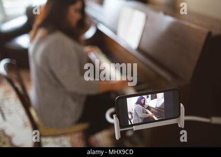 Belle femme jouant du piano vlogger Banque D'Images