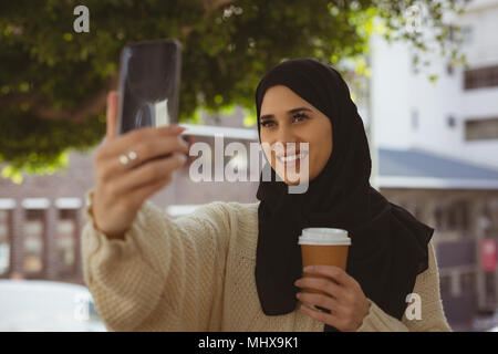 Hijab femme qui téléphone mobile avec selfies Banque D'Images