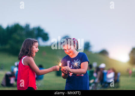 Girls holding sparklers smiling Banque D'Images