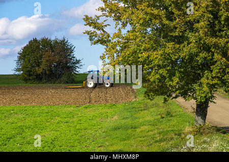 L'agriculture en milieu rural avec le tracteur et harrow sur un champ à la fin de l'été - début de l'automne. Banque D'Images