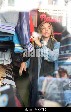 Jeune femme parcourt en vêtements vintage thrift store Banque D'Images