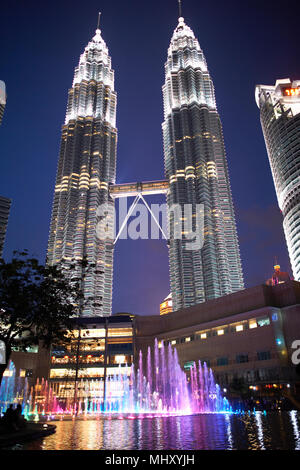 Les Tours Petronas illuminé la nuit, low angle view, Kuala Lumpur, Malaisie Banque D'Images