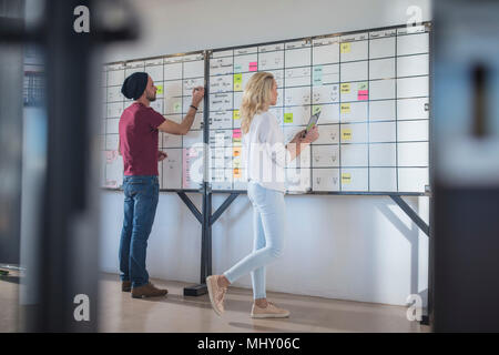 Collègue masculins et féminins des idées de planification sur tableau blanc bureau Banque D'Images