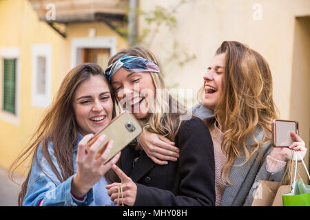 Les amis de prendre la rue en selfies Banque D'Images