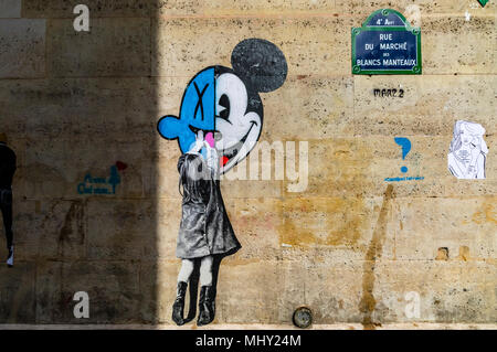 Une petite fille atteint jusqu'à toucher la souris de Mickey, une peinture de rue sur un mur de la rue du marché des Blancs Manteaux, Paris, France Banque D'Images