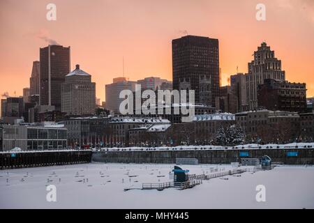 Vue sur le centre-ville de Montréal photographié à partir de l'ancien port que le soleil se couche derrière les immeubles, Montréal, Canada. Banque D'Images