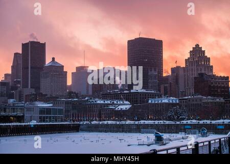 Vue sur le centre-ville de Montréal photographié à partir de l'ancien port que le soleil se couche derrière les immeubles, Montréal, Canada. Banque D'Images