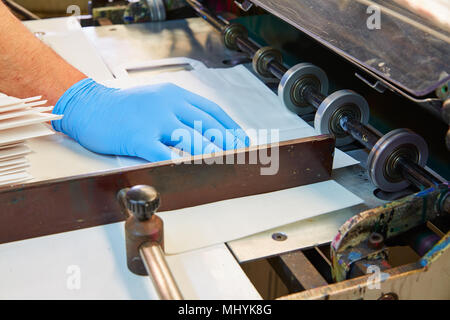 Machine d'impression Flexo dans une usine d'impression détails de la main de l'opérateur Banque D'Images