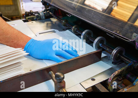 Machine d'impression Flexo dans une usine d'impression détails de la main de l'opérateur Banque D'Images