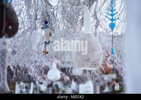 Une scène d'hiver avec des objets artisanaux décoratifs de calabash gourd blanc, poisson en bois coloré et lampes hippocampes accrochée à un arbre Banque D'Images