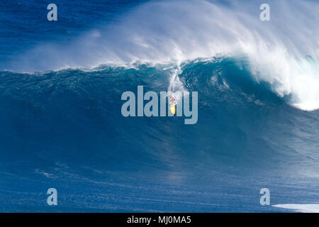 Surfer à Peahi Maui, Hawaii, également connu sous le nom de mâchoires. Big Wave surfers repoussez les limites de la pagaie dans le surf. Banque D'Images