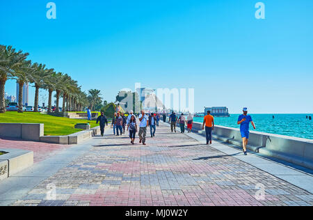 DOHA, QATAR - février 13, 2018 : La foule Al Corniche, promenade dans le quartier de West Bay avec bâtiment moderne de Sheraton Grand Resort sur backgroun Banque D'Images