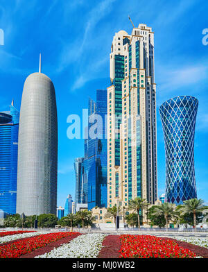 Les lits de fleurs en face de la gratte-ciel futuriste de West Bay, le quartier moderne centre d'affaires de Doha, au Qatar. Banque D'Images