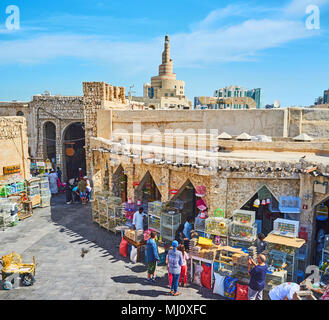 DOHA, QATAR - février 13, 2018 : la place du commerce dans le marché d'oiseaux Souq Waqif avec arcade en pierre longue et minaret de la mosquée sur le contexte, Fanar sur F Banque D'Images