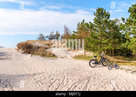 Prêt de vélos stationnés près d'entrée de belle plage de sable. La mer Baltique, la Pologne. Banque D'Images