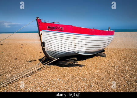 Un bateau de pêche en bois nommée REBECCA en cours de restauration sur la plage de galets à Dungeness, Sussex, Angleterre Banque D'Images