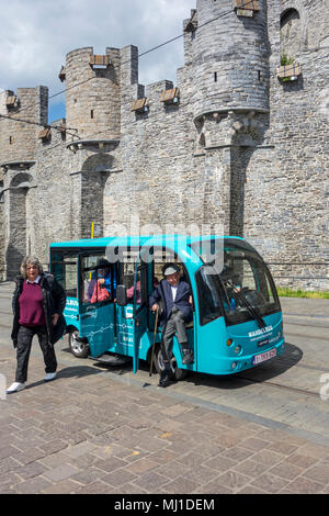 Personnes âgées touristes sortant de Keolis bus marche / Wandelbus, electric People Mover équitation dans le centre-ville historique de Gand, Flandre orientale, Belgique Banque D'Images