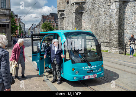 Personnes âgées touristes sortant de Keolis bus marche / Wandelbus, electric People Mover équitation dans le centre-ville historique de Gand, Flandre orientale, Belgique Banque D'Images