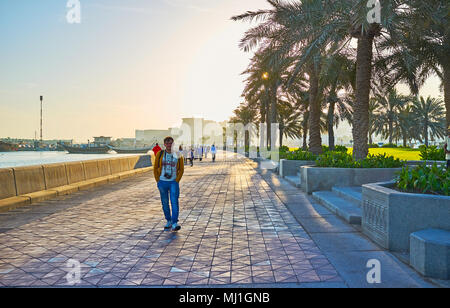 DOHA, QATAR - février 13, 2018 : le matin en corniche promenade avec vue sur quelques personnes et bateaux dhow Harbour à Doha, le 13 février à Doha Banque D'Images