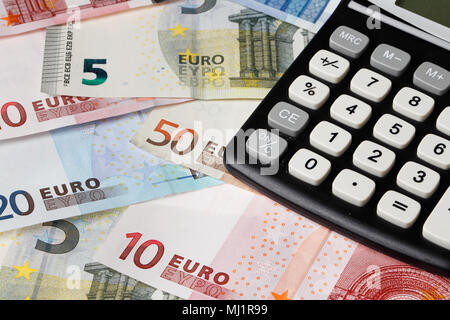 Une calculatrice noire sur les billets en euros dans les différentes coupures. Banque D'Images