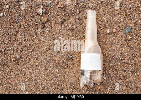 Bouteille de verre cassée sur le sable au désert d'Atacama. Mejillones, Antofagasta, Chili. Banque D'Images