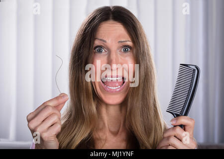 Choqué femme souffrant de problème de perte de cheveux Banque D'Images