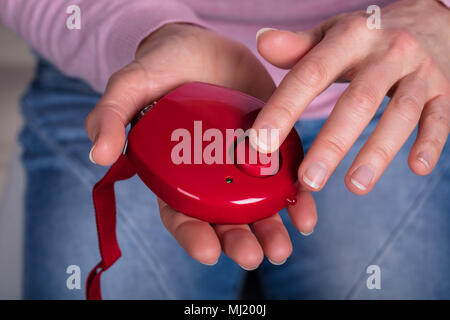 Close-up of Woman's Hand en appuyant sur le bouton d'alarme personnelle Banque D'Images