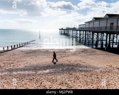 Homme marchant sur la plage byTeignmouth pier, Devon, UK Banque D'Images