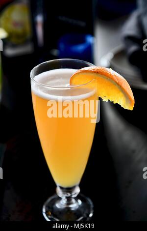 Haut de choc la bière servi sur le projet de garnie d'une tranche d'orange pour l'happy hour Banque D'Images