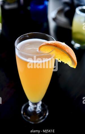 Haut de choc la bière servi sur le projet de garnie d'une tranche d'orange pour l'happy hour Banque D'Images