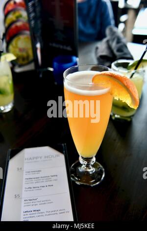 Haut de choc la bière servi sur le projet de garnie d'une tranche d'orange pour l'happy hour Banque D'Images