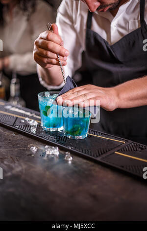 Barman est en remuant des cocktails sur comptoir bar Banque D'Images