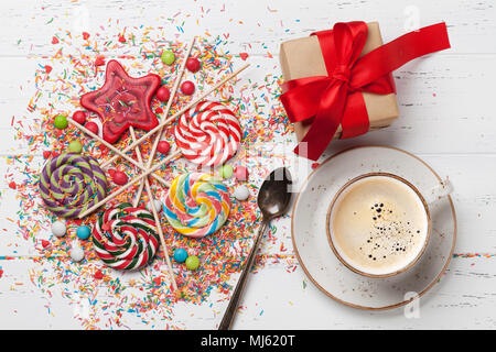 Bonbons colorés. Sucettes, bonbons, tasse à café et boîte-cadeau. Vue d'en haut Banque D'Images