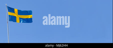 Le drapeau suédois vole sur ciel bleu. Banque D'Images