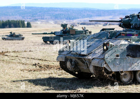 Un véhicule de combat Bradley M2 et d'un groupe de chars Abrams M1 avec la 2ème Armored Brigade Combat Team, 1re Division d'infanterie, sécuriser une zone au cours d'une infraction complexe robotique à Grafenwoehr de démonstration du concept d'entraînement, l'Allemagne, le 6 avril 2018. Le complexe robotique emploie le concept de violation l'utilisation de la Robotique et Systèmes Autonomes (RAS) pour l'intelligence, de suppression, d'obscurcissement, et de réduction des missions. (U.S. Collection d'images de l'Armée de célébrer le dévouement la bravoure et le sacrifice de l'engagement des Forces armées des États-Unis et du personnel civil. Banque D'Images