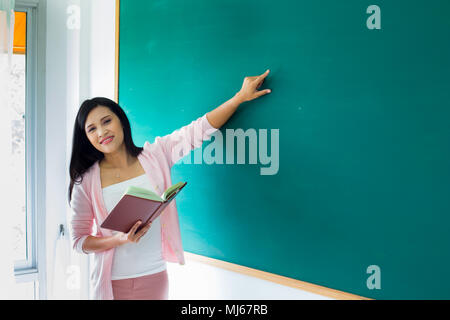 Portrait de femme près de l'enseignant en classe tableau noir Banque D'Images