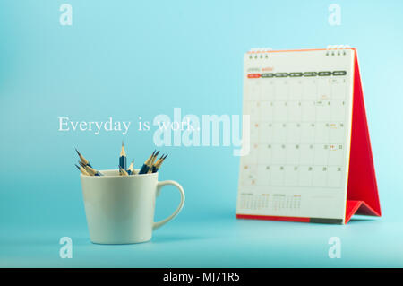 Crayons en blanc tasse avec calendrier et horloge sur fond bleu, concept que chaque jour est le travail. Banque D'Images