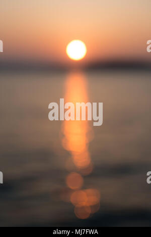 Soleil de flou artistique et l'eau de mer en soirée. Coucher du soleil, l'arrière-plan. Banque D'Images