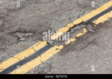 Chaussée endommagée de Yokohl dur en Californie, Etats-Unis - asphalte fissuré blacktop avec poule et correctifs. Banque D'Images