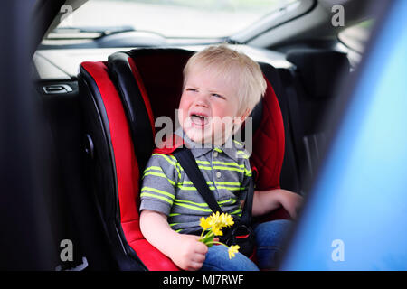 Baby Boy blondes qui crie dans un siège d'auto pour enfants Banque D'Images