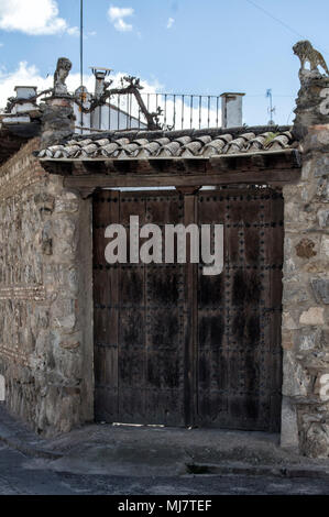 Porte en bois avec toit sur une façade en pierre d'une maison à Puebla de Montalban, province de Tolède. Castilla la Mancha en Espagne. Banque D'Images