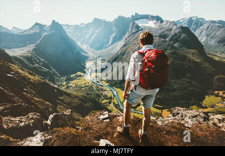 Randonnée solitaire dans les montagnes de la Norvège avec l'homme sac à dos rouge bénéficiant paysage sur falaise voyage solo de vie sain concept active summer vacations Banque D'Images