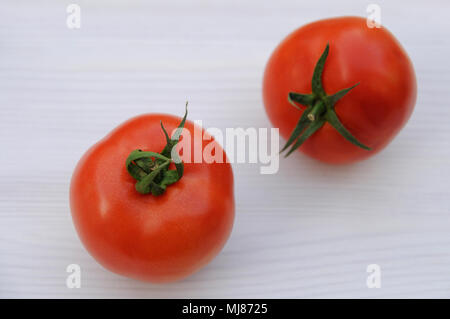 Deux tomates rouges sur fond de bois blanc Banque D'Images