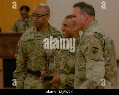 Le Sergent Aaron Chavers (centre), jointe à la 198th Army Band, 99e Division, se trouve à côté de l'état de préparation au major général A. C. Roper, général commandant de la 76e commandement de l'intervention opérationnelle (à gauche) et commande le Sgt. Le major Arlindo Almeida, sous-officier de l'état de préparation de la 99e Division (à droite), à la formation des Forces de réserve Devens Domaine dans le Massachusetts, le 19 avril 2018. Chavers gagne le titre de meilleur guerrier, pour son commandement, dans la commande principale niveau Concours meilleur guerrier. (U.S. Réserve de l'armée photo de Pvt. Hunter E. Eastman) (Photo recadrée et édité pour l'effet.) Banque D'Images