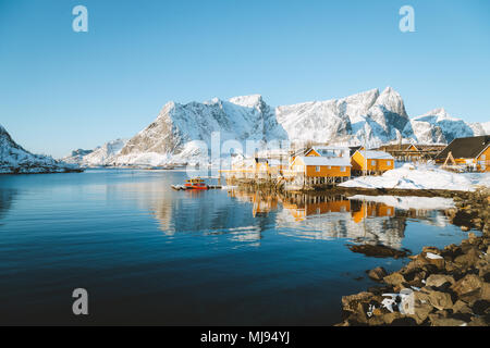 Beaux paysages d'hiver dans l'archipel des îles Lofoten avec pêcheur traditionnel jaune Rorbuer cabines dans le village historique de Sakrisoy, Norvège Banque D'Images